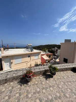 a house with potted plants on a stone patio at House of Happiness Rhodos in Kritinía