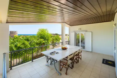 a patio with a table and chairs on a balcony at Villa Euphoria in Gennadi