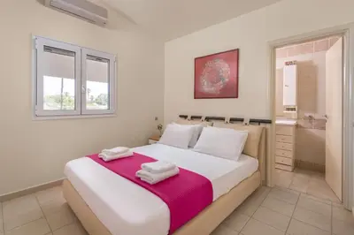 a bedroom with a large bed with towels on it at Villa Euphoria in Gennadi