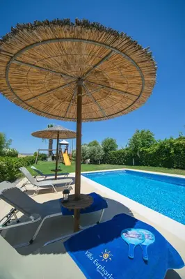 a large umbrella sitting next to a swimming pool at Villa Euphoria in Gennadi