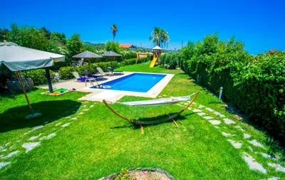 a yard with a hammock and a swimming pool at Villa Euphoria in Gennadi