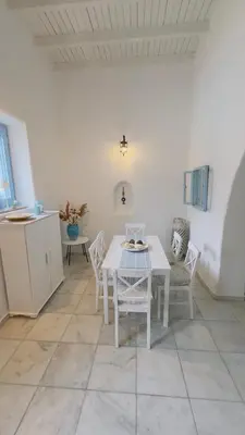 a white dining room with a table and chairs at ''TSI TSI' traditional home & private Pool' in Kalithies