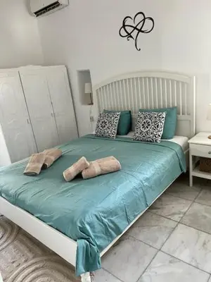 a bedroom with a bed with blue sheets and pillows at ''TSI TSI' traditional home & private Pool' in Kalithies