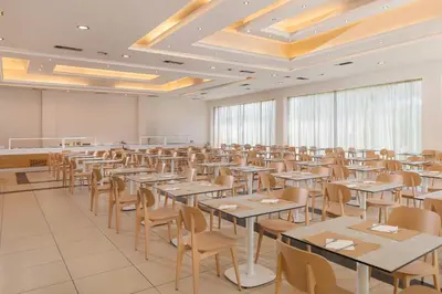 a large room with tables and chairs in it at Afandou Bay Village Resort Hotel in Afantou