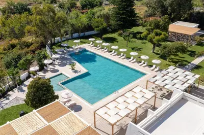 an overhead view of a swimming pool with chairs and trees at Afandou Bay Village Resort Hotel in Afantou