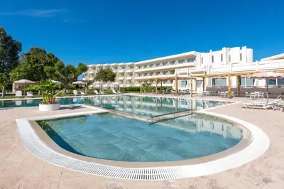 a large swimming pool in front of a building at Afandou Bay Village Resort Hotel in Afantou