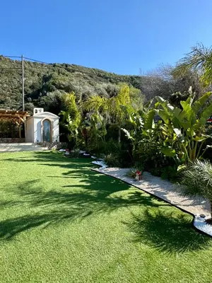 a garden with a grass yard with a building at City Compass Sunset Villa in Rhodes Town