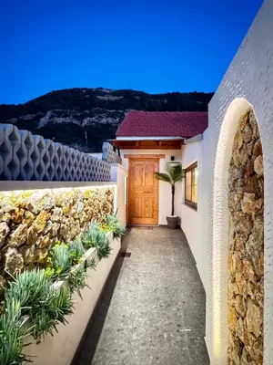 a house with a stone wall and a wooden door at City Compass Sunset Villa in Rhodes Town