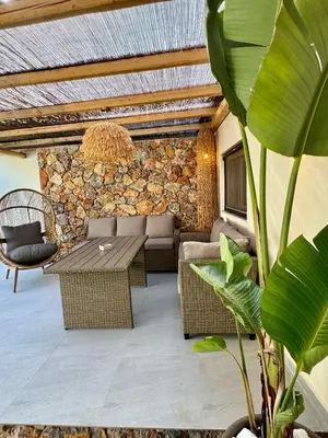 a patio with a table and chairs and a stone wall at City Compass Sunset Villa in Rhodes Town