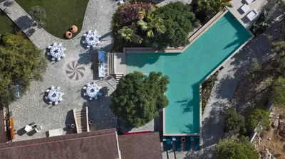 an overhead view of a swimming pool with tables and chairs at Palazzo Navarone in Líndos