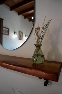 a vase sitting on a wooden shelf with a mirror at Vavana Studios in Symi
