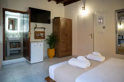 a bedroom with a bed and a refrigerator and a sink at Vavana Studios in Symi