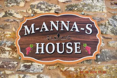 a sign for a mamaannis house on a stone wall at Mannas House 2 in Émbonas