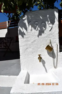a wall with a shadow of a bell and a beeper at Mannas House 2 in Émbonas