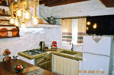 a kitchen with a stove and a white refrigerator at Mannas House 2 in Émbonas