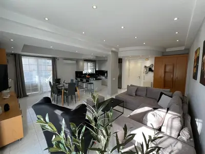 a living room with a couch and a dining room at Aura Apartment in Rhodes Town