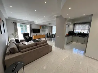 a large living room with a couch and a kitchen at Aura Apartment in Rhodes Town