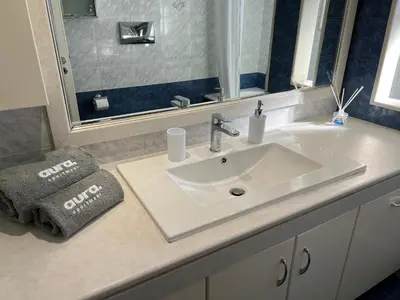 a bathroom with a white sink and a mirror at Aura Apartment in Rhodes Town