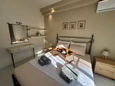 a bedroom with a bed with a table and a mirror at Aura Apartment in Rhodes Town