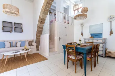a living room with a blue table and chairs at Melenia House in Koskinou