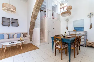 a living room with a blue table and chairs at Melenia House in Koskinou