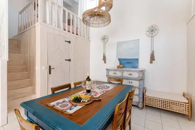 a dining room with a blue table and chairs at Melenia House in Koskinou