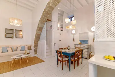 a kitchen and living room with a table and chairs at Melenia House in Koskinou