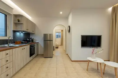 a kitchen with a refrigerator and a tv on the wall at Kathy's apartments in Archaggelos in Archangelos