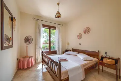 a bedroom with a large bed and a window at Villa Russelia in Kalavárda
