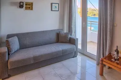 a couch in a living room with a view of the ocean at Haraki style studio in Haraki
