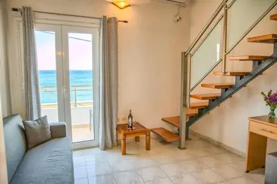 a living room with a staircase and a view of the ocean at Haraki style studio in Haraki