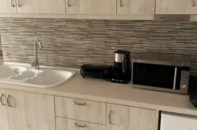 a kitchen counter with a microwave and a sink at Haraki style studio in Haraki