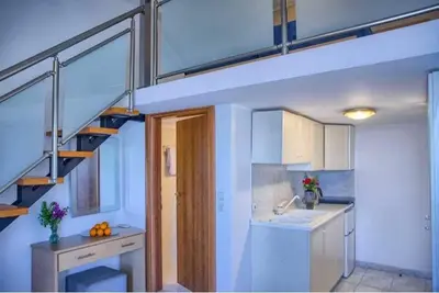 a small kitchen with a staircase in a room at Haraki style studio in Haraki