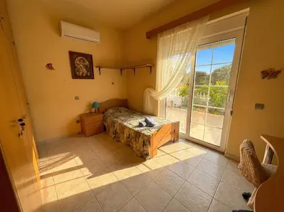 a bedroom with a bed and a large window at Tharreni's house in Lindos in vlicha