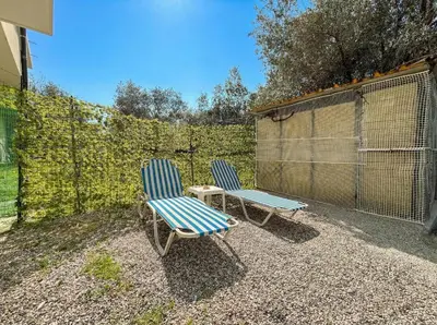 two blue chairs and a table in a backyard at Tharreni's house in Lindos in vlicha