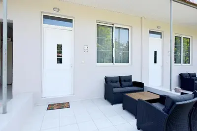 a porch with two chairs and a table and windows at Liri - Family paradise in Ialyssos