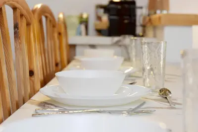 a table with white bowls and plates on it at Liri - Family paradise in Ialyssos