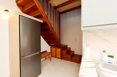 a kitchen with a stainless steel refrigerator and a staircase at Liri - Family paradise in Ialyssos