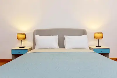 a bedroom with a bed with two lamps on tables at Liri - Family paradise in Ialyssos
