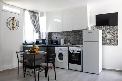 a kitchen with a washing machine and a table with chairs at Cozy studio in Rhodes Town