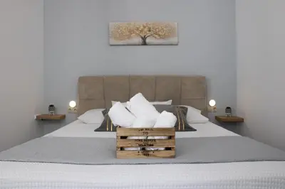 a bedroom with a bed with white sheets and pillows at Cozy studio in Rhodes Town