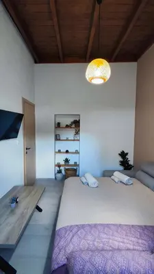 a bedroom with a large bed and a chandelier at Luna Grande in Archangelos