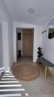 a hallway with a rug and a table and a door at Luna Grande in Archangelos