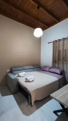 a bedroom with a large bed and a couch at Luna Grande in Archangelos