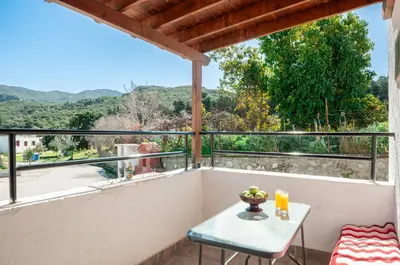 a table and chairs on a balcony with a view at Giannis Place in Arnítha