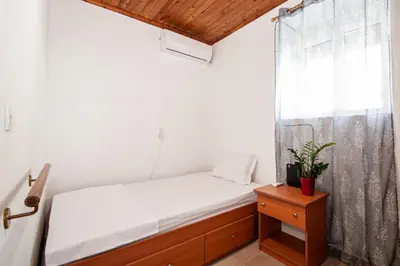 a small bedroom with a bed and a window at Giannis Place in Arnítha