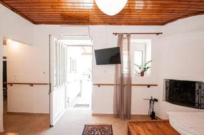 a living room with a sliding door and a tv at Giannis Place in Arnítha