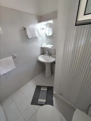 a bathroom with a white toilet and a sink at Pefkos Crystal Bay SELF-CATERED Studios and Apartments in Pefki Rhodes