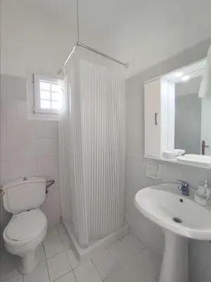 a white bathroom with a toilet and a sink at Pefkos Crystal Bay SELF-CATERED Studios and Apartments in Pefki Rhodes