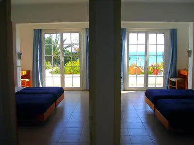 a bedroom with two beds and a view of the ocean at Pefkos Crystal Bay SELF-CATERED Studios and Apartments in Pefki Rhodes